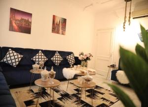 a living room with a blue couch and two tables at اجنحة الصفوة in Jeddah