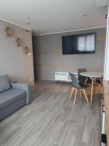 ein Wohnzimmer mit einem Sofa und einem Tisch in der Unterkunft Mieszkanie w centrum Tarnowa 2.0 in Tarnów