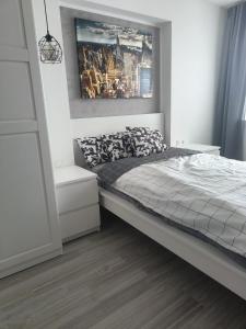 a bedroom with a bed and a painting on the wall at Mieszkanie w centrum Tarnowa 2.0 in Tarnów