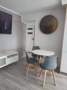 ein Esszimmer mit einem Tisch, 2 Stühlen und einer Uhr in der Unterkunft Mieszkanie w centrum Tarnowa 2.0 in Tarnów