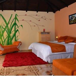 a bedroom with a bed and a red rug at Orquideas Runtun in Baños