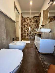 ein Badezimmer mit zwei Waschbecken, einem WC und einer Badewanne in der Unterkunft B&B Hakuna Matata in Alghero