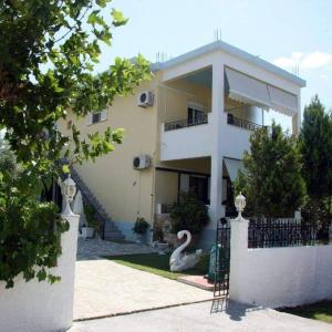 a building with a swan statue in front of it at Koletsis Rooms (Villa Koletsis) in Ammoudia