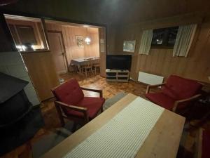 ein Wohnzimmer mit einem Tisch, Stühlen und einem TV in der Unterkunft Trevet by Norgesbooking - cabin close to skicenter in Holo