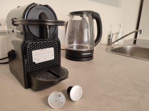 a black blender sitting on a counter next to a sink at Modernes zentrales Apartment in Bruchsal