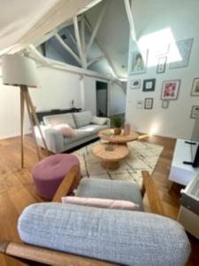 een woonkamer met een bank en een tafel bij Loft de 110m² dans le cœur historique d'Angers in Angers