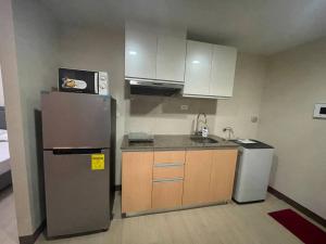 uma pequena cozinha com um frigorífico e um lavatório em High speed internet - Cozy 1BR fully Furnished em Manila
