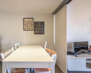 Una habitación con una mesa y sillas y un televisor. en Montebella at Portuguese Riviera ESTORIL, en Estoril