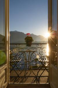 a table on a balcony with a flower pot on it at NELL'A COMO in Griante Cadenabbia