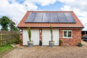 a house with solar panels on the roof at Suffolk Fieldview Country Cottage in Toft Monks