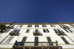 a tall white building with windows and balconies at NELL'A COMO in Griante Cadenabbia