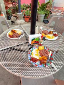 a table with plates of breakfast food on it at Guest House Nena in Moyogalpa