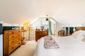 a bedroom with a large white bed and a dresser at Suffolk Fieldview Country Cottage in Toft Monks