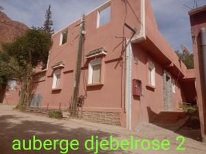 une maison rose avec les mots ridge ridgelez dans l'établissement auberge djebel rose 2, à Tafraout