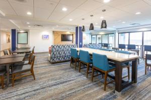 a conference room with tables and chairs and a couch at Holiday Inn Express Hotel & Suites Jacksonville Airport, an IHG Hotel in Jacksonville