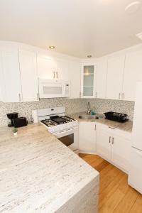 a kitchen with white cabinets and a counter top at Charming 2-Bed Apt Mins from NYC - Sleeps 7 in Union City