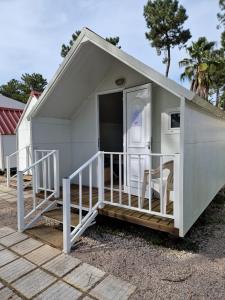 a small shed with a porch and a refrigerator at Valbom by Campigir in Sesimbra