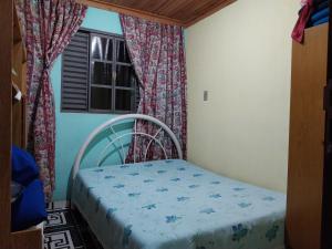 Cama pequeña en habitación con ventana en Hospedagem Manacás, en Alagoa