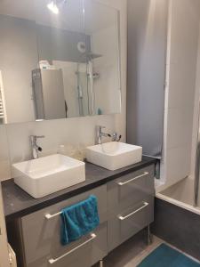 uma casa de banho com 2 lavatórios e um espelho em Appartement T4 J024 - 5 min de marche VTT -10 min Vélodrome dans résidence agréable 6 pers em Élancourt