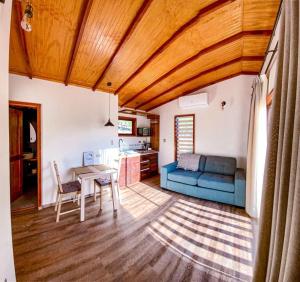 a living room with a blue couch and a table at Cabañas Boutique Faldeos de La Lajuela in Santa Cruz