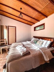 1 cama grande en un dormitorio con techo de madera en Cabañas Boutique Faldeos de La Lajuela, en Santa Cruz
