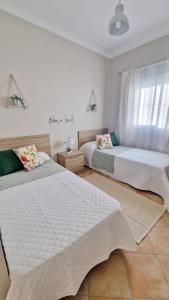 a bedroom with two beds and a window at Villas Luins in Chiclana de la Frontera +55 photos