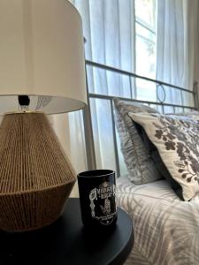 a lamp and a cup on a table next to a bed at Remarkable 2-Bed House in London in London