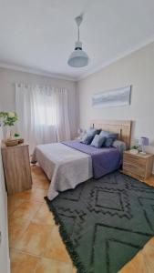 1 dormitorio con 1 cama grande y 1 alfombra en Villas Luins, en Chiclana de la Frontera