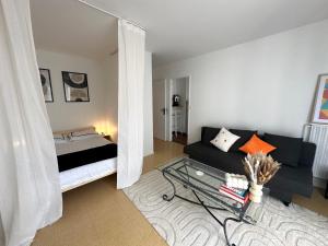 - un salon avec un canapé et un lit dans l'établissement Le Gambetta Paris, à Paris