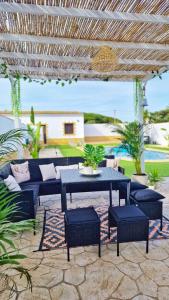 un patio con mesa y sillas bajo una pérgola en Villas Luins, en Chiclana de la Frontera