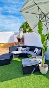 a patio with two couches and an umbrella at Villas Luins in Chiclana de la Frontera