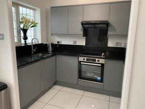 a kitchen with white cabinets and a stove top oven at Casa Elisa in Enfield