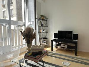 - un salon avec une table en verre et une télévision dans l'établissement Le Gambetta Paris, à Paris
