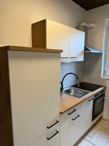 a kitchen with white cabinets and a sink at Schöne EG Wohnung mit TV, Wlan und Küche - Maria in Werne an der Lippe