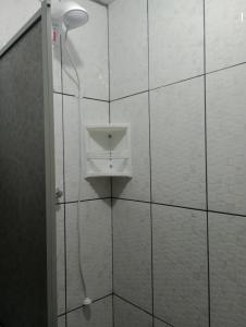 La salle de bains est pourvue d'une douche avec un pommeau de douche. dans l'établissement Hotel Pousada Roma, à Caràzinho