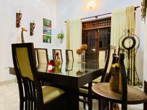 a dining room with a glass table and chairs at Lukshmie Villa in Ja-Ela