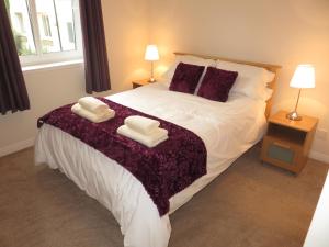 a bedroom with a large bed with two towels on it at Waverley Park Apartment in Edinburgh