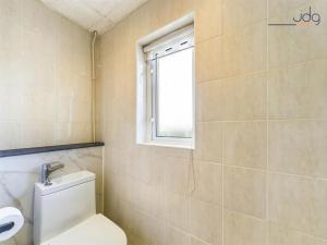a bathroom with a toilet and a window at 1 Buttermere road in Lancaster
