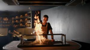 un hombre parado frente a un horno de fuego en Hotel Indigo Brisbane City Centre, an IHG Hotel en Brisbane