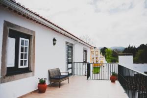 uma varanda de uma casa branca com um banco em Casa de Campo da Quinta da Pegada em Óbidos