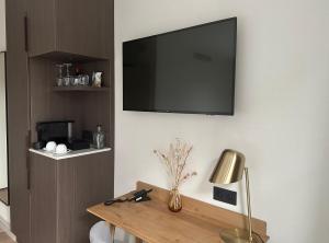 a living room with a tv on the wall at Hotel Flora Batava in Breukelen