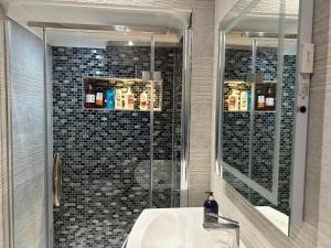 uma casa de banho com um lavatório e um chuveiro com um espelho. em A luxury double bedroom with ensuite in High Wycombe em Buckinghamshire