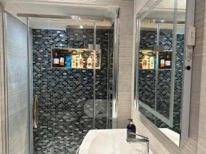 a bathroom with a sink and a shower with a mirror at A luxury double bedroom with ensuite in High Wycombe in Buckinghamshire