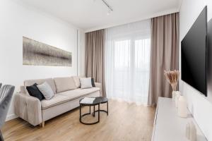a white living room with a couch and a table at Warsaw View Prestige Apartment in Warsaw