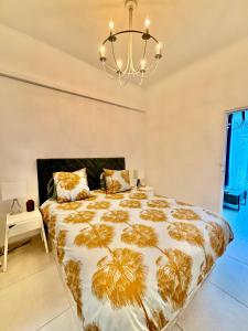 ein Schlafzimmer mit einem großen Bett und einem Kronleuchter in der Unterkunft Le Malezi au du village des Pennes Mirabeau in Les-Pennes-Mirabeau