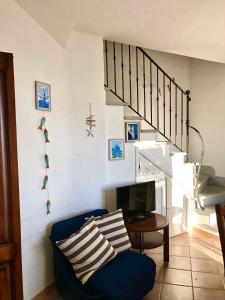 a living room with a blue couch and a staircase at Casa Bellavista in Nebida