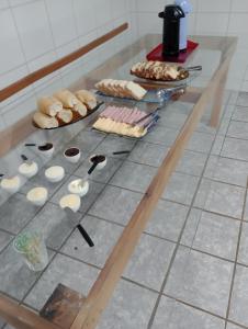 uma mesa com pão e bolos em Hotel Pousada Roma em Caràzinho