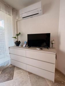 Televízia a/alebo spoločenská miestnosť v ubytovaní Logement climatisé à seulement 3 minutes à pied de la mer
