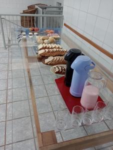 a counter with wine glasses and food on it at Hotel Pousada Roma in Caràzinho