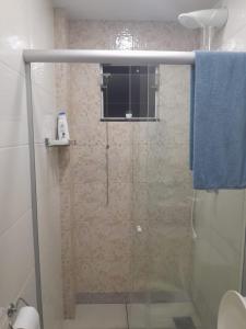 La salle de bains est pourvue d'une douche avec une porte en verre. dans l'établissement Quarto próximo Av JK, à Patos de Minas